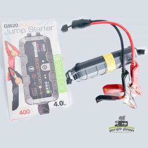 מתנע נייד מדגם NOCO-GB20 12V ‏(400A, למנועי בנזין) עם מלחציים מחוברים מוצג ליד הקופסה שלו, הכוללת מיתוג ופרטים המדגישים את תפקידה כתחנת כוח ניידת (תחנת כוח ניידת) המיועדת לשילוב עם פאנלים סולאריים וטכנולוגיה פוטו-וולטאית, התומכת בייצור אנרגיה נקייה ותשתית אנרגיה מתחדשת.