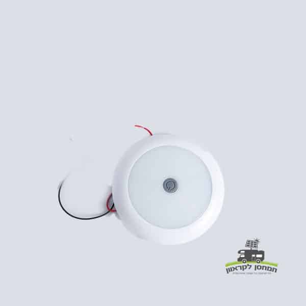תאורת LED עגולה 12V עם מתג מרכזי, גימור לבן, חוטים חשופים, ומתאימה לשילוב במערכות אנרגיה סולארית או קרוואנים וציוד מחנאות המונעים על ידי פוטו. אידיאלי עבור תשתית אנרגיה מתחדשת ופתרונות ייצור חשמל מחוץ לרשת. מוצג על רקע בהיר עם לוגו עברי קטן בפינה הימנית התחתונה.